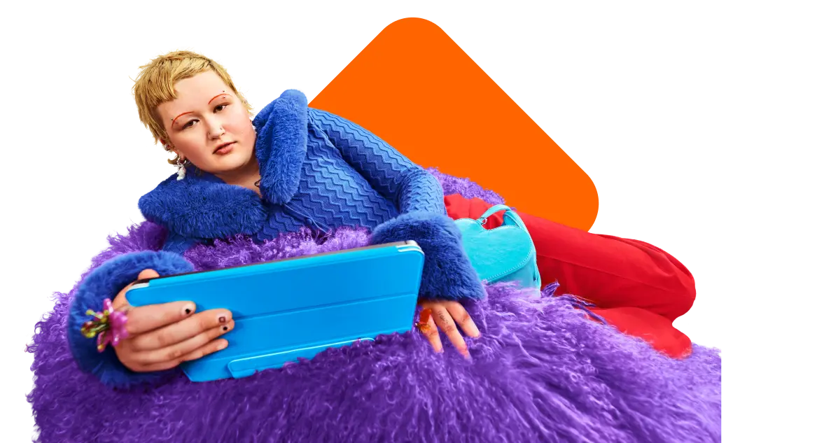 Person sitzt mit Tablet auf einem Sitzkissen.