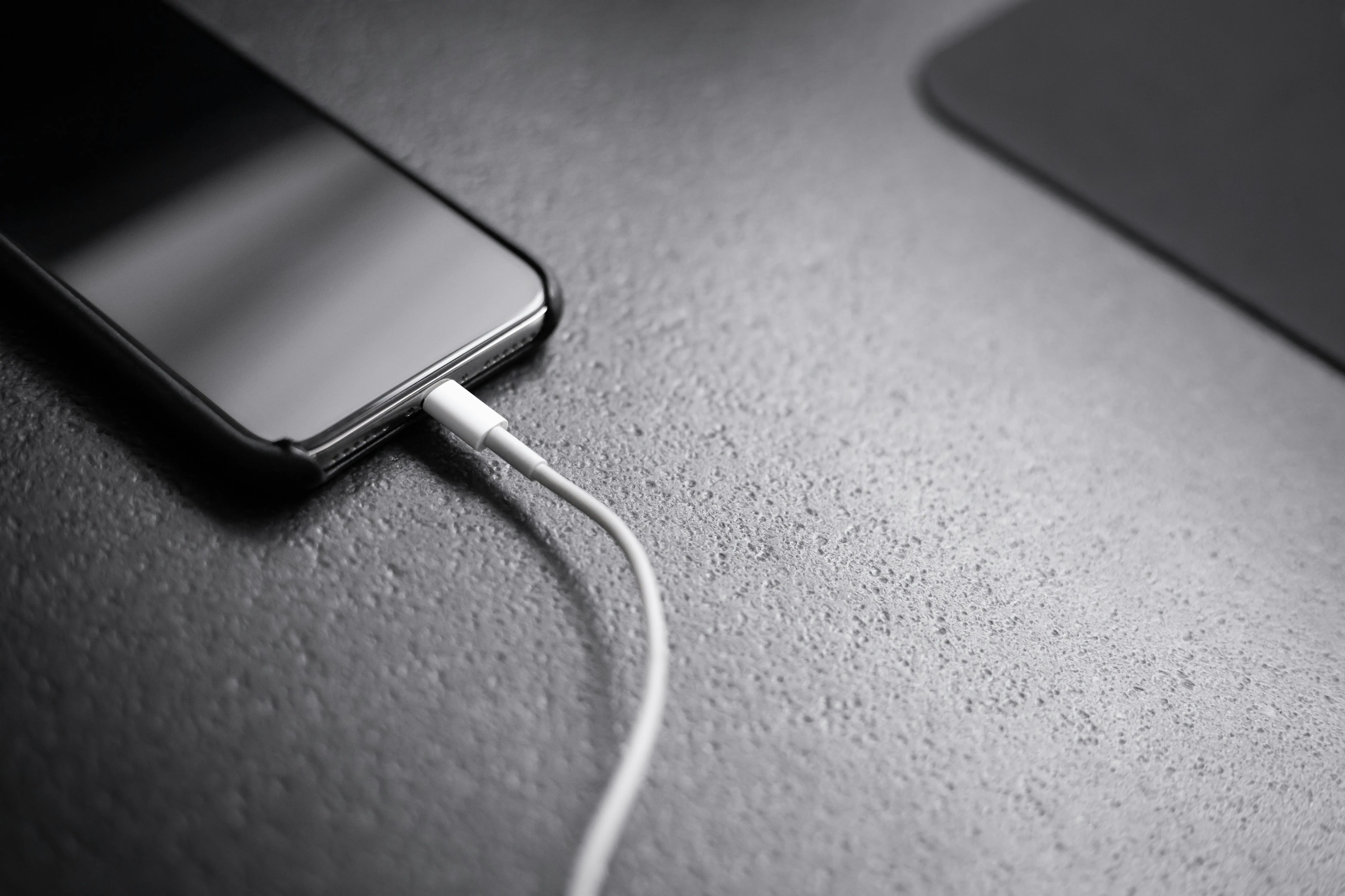 Handy hängt ausgeschaltet am Ladekabel
