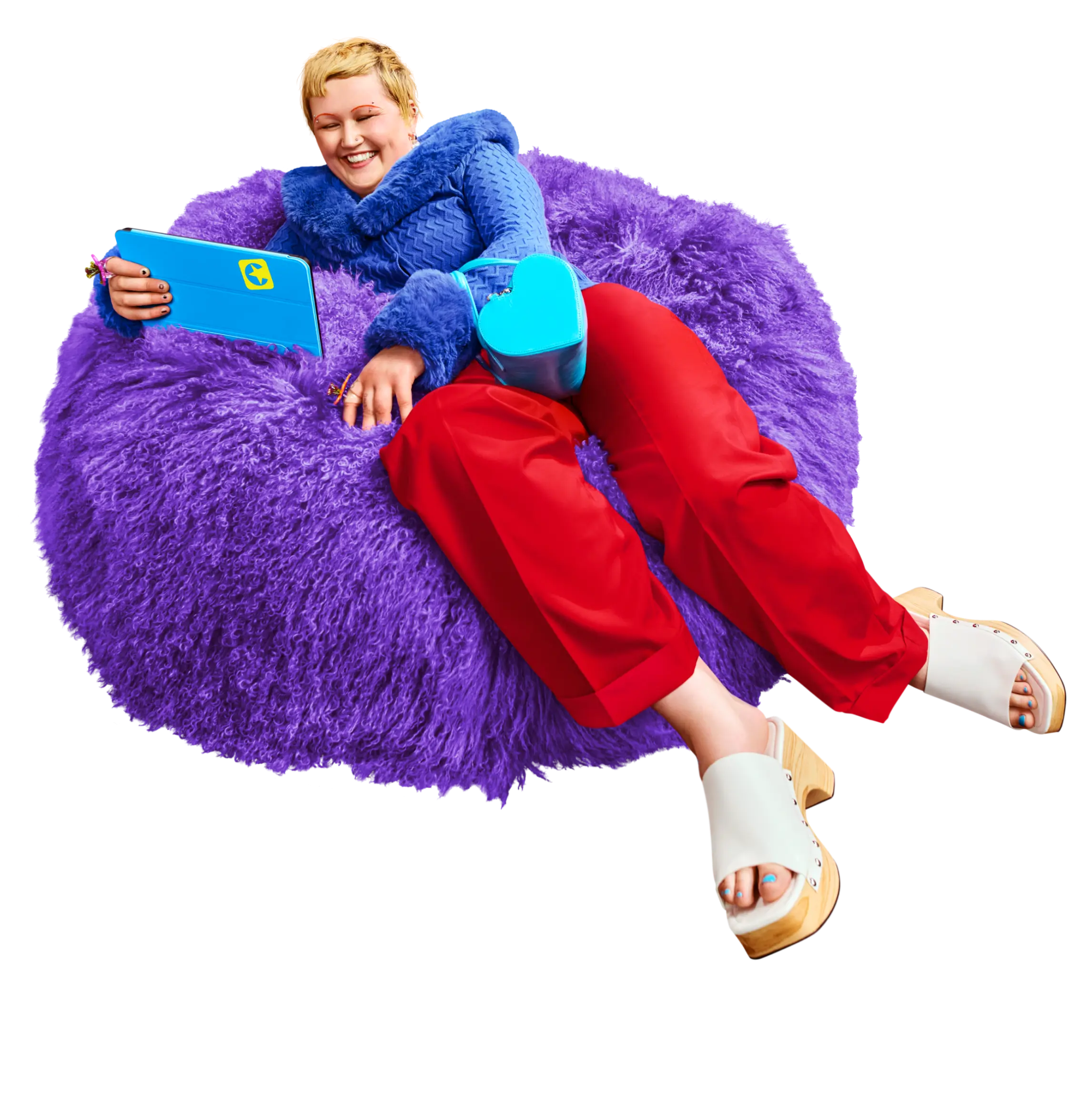 Lächelnde Person sitzt mit Tablet auf einem Sitzkissen.