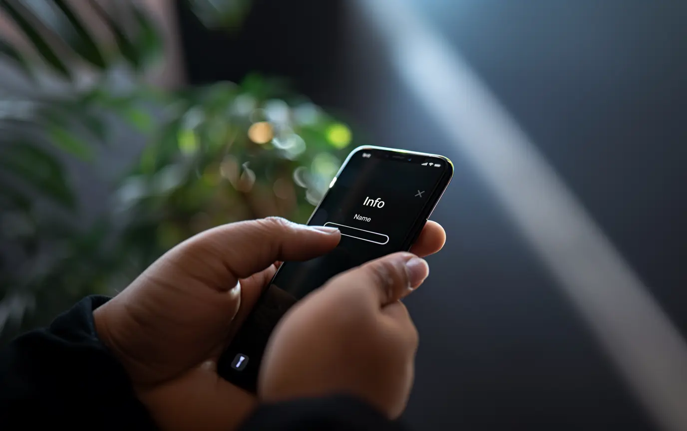 Jemand hält ein iPhone in der Hand, um den Namen zu ändern