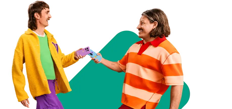 Zwei lächelnde Personen reichen sich gegenseitig ein Smartphone.