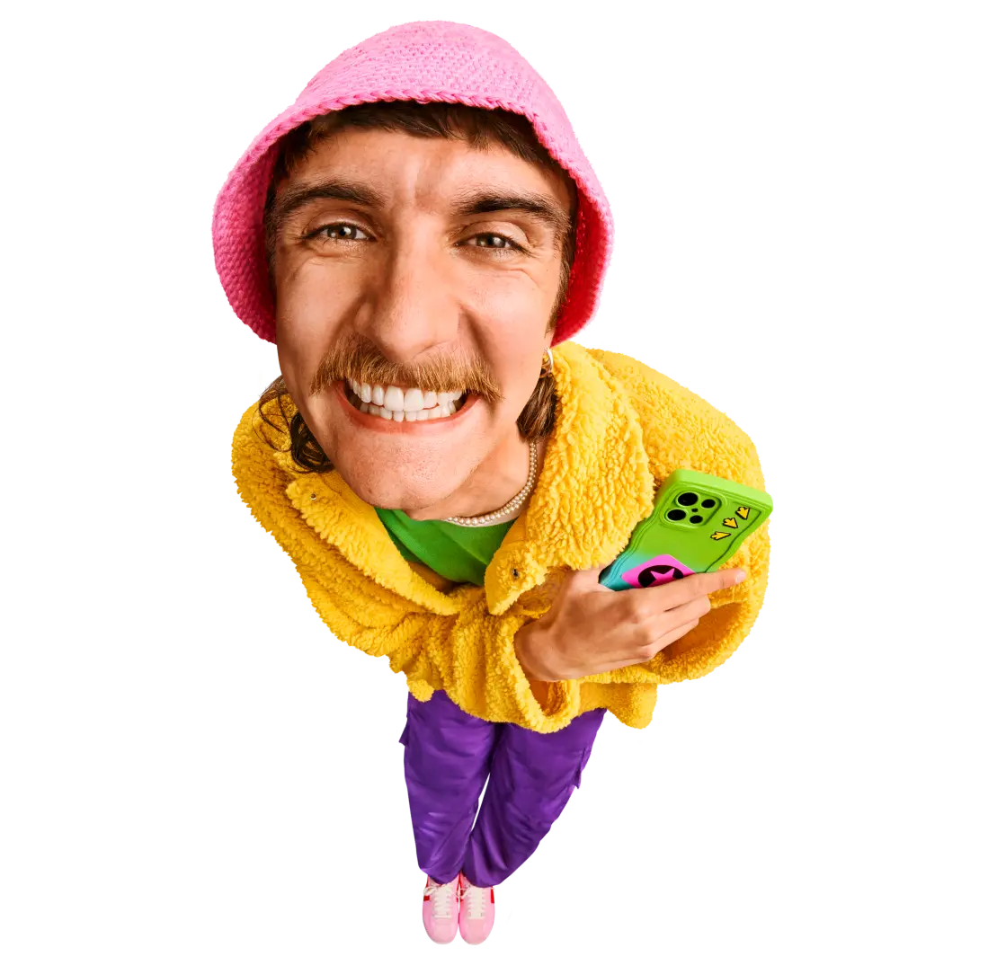 Person lächelt in die Kamera und hält ein Smartphone in der Hand.