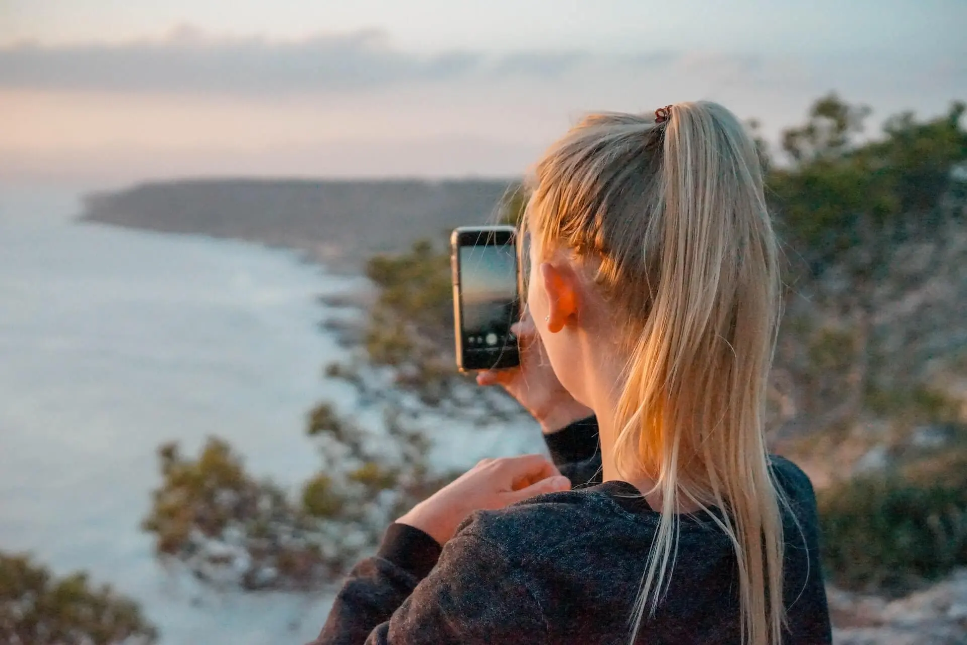 Frau macht Foto von einer Landschaft
