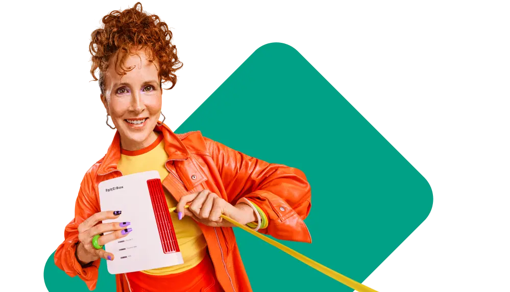 Eine lächelnde Person hält eine FRITZ!Box und zieht an einem Netzwerkkabel.