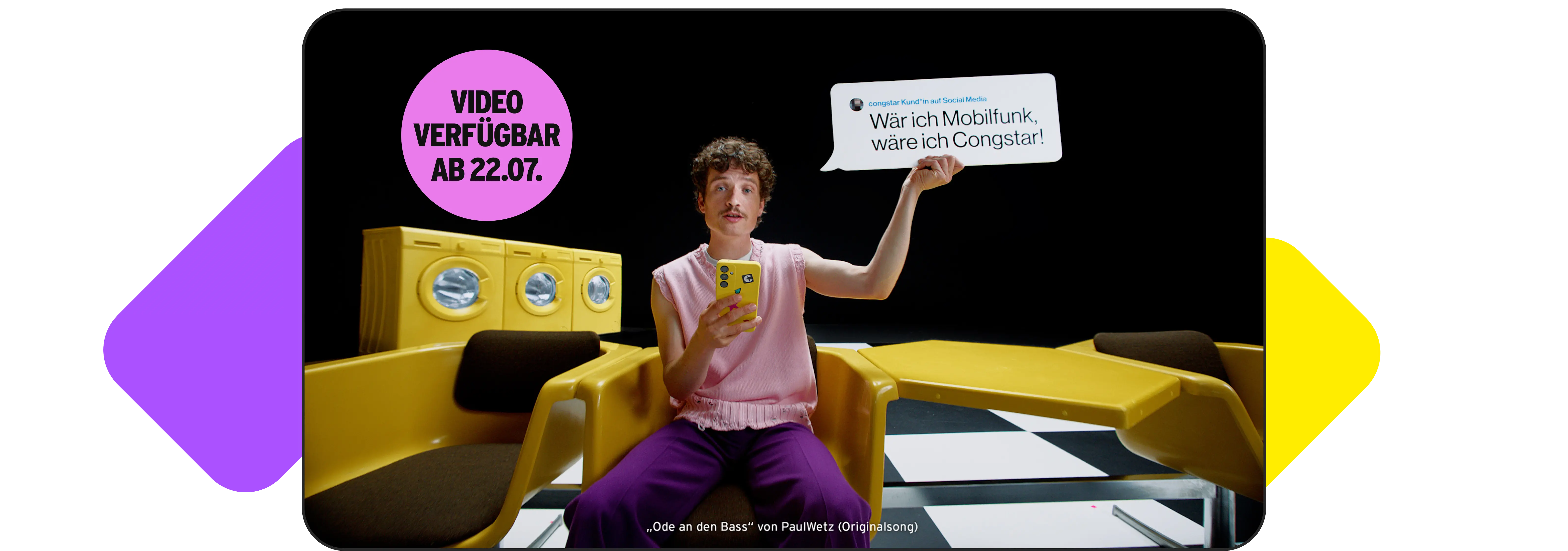 Ein Bild, das eine Video-Vorschau und Textinformationen kombiniert. Innerhalb des Video-Rahmens sitzt eine Person mit Schnurrbart, pinkem Top und lila Hose auf einem gelben Stuhl und hält ein gelbes Smartphone. Die Person hält eine kleine Sprechblase hoch, die einen Kommentar einer congstar Kund*in auf Social Media zeigt: "Wär ich Mobilfunk, wäre ich Congstar!". Im Hintergrund der Szene sind gelbe Waschmaschinen und ein schwarz-weiß karierter Boden zu sehen. Über dem Video liegt ein großer pinker Kreis mit der Ankündigung "VIDEO VERFÜGBAR AB 22.07.". Unter dem Rahmen steht der Songtitel „Ode an den Bass" von PaulWetz (Originalsong). Abstrakte orange und lila Formen sind in den oberen und unteren Ecken außerhalb des Video-Rahmens auf schwarzem Hintergrund zu sehen.