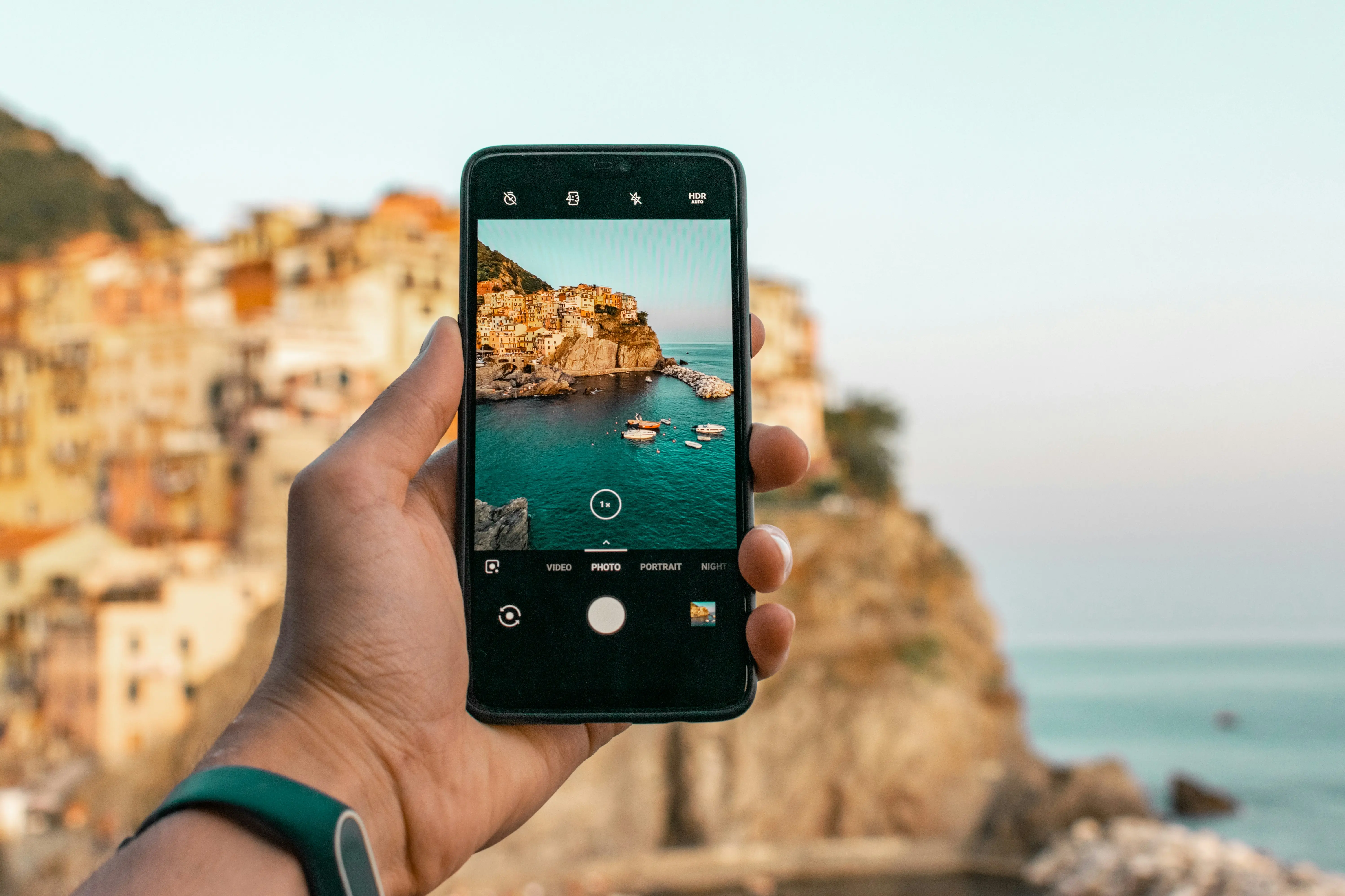 Person macht Foto von Klippen am Meer