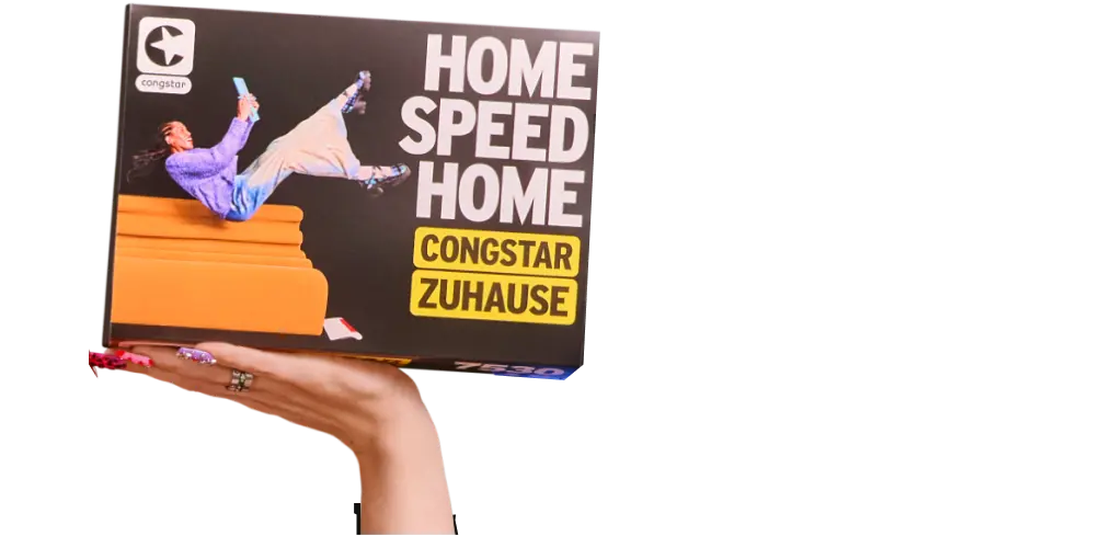 Eine Hand hält eine congstar-Produktverpackung mit der Aufschrift „Home Speed Home – congstar Zuhause" in die Höhe.