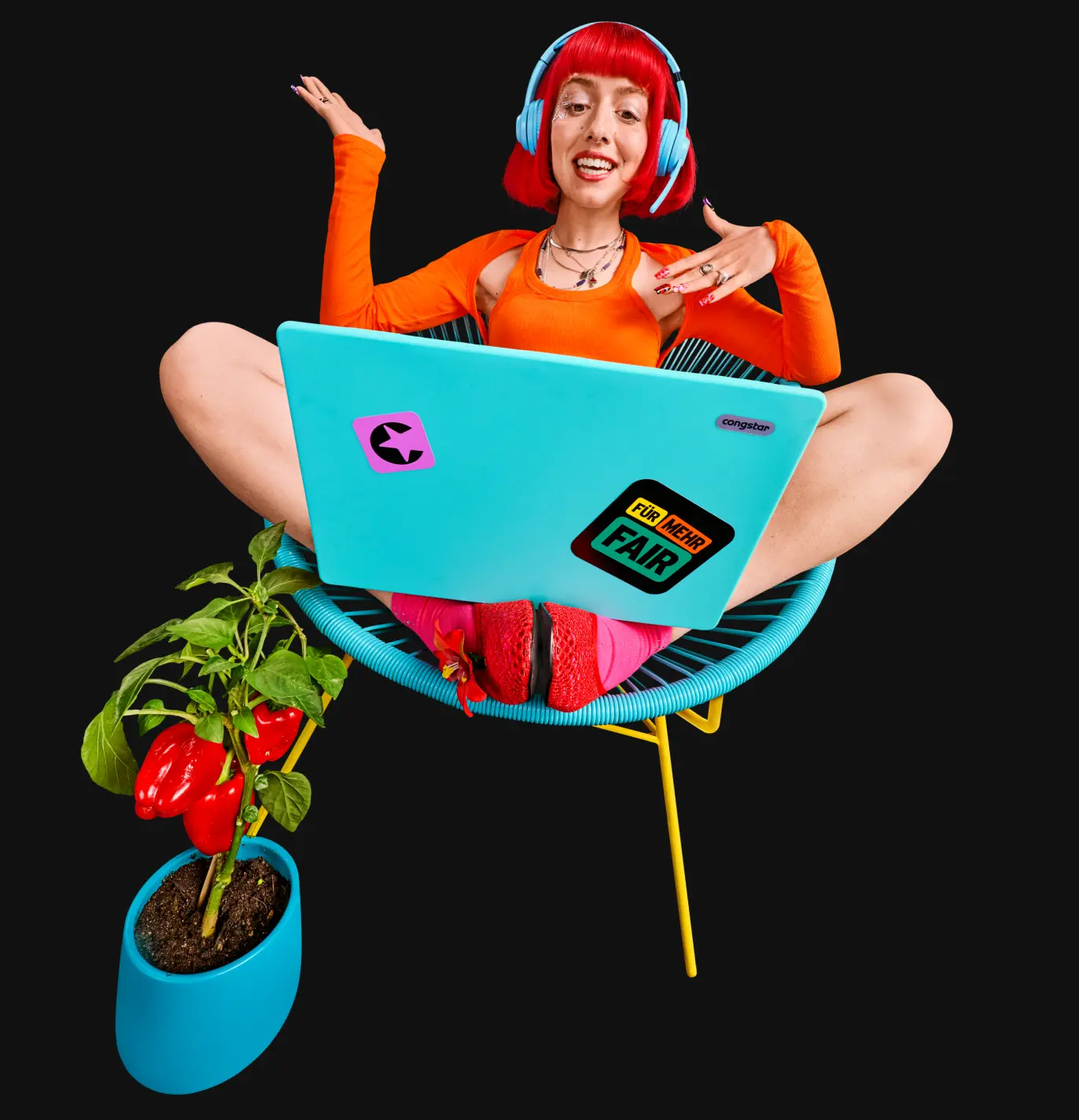 Lächelnde Person sitz mit Laptop und Kopfhörern auf einem Stuhl.