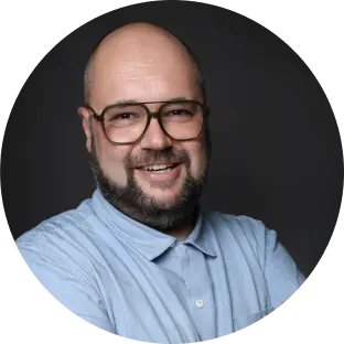 Mann lächelt in die Kamera.