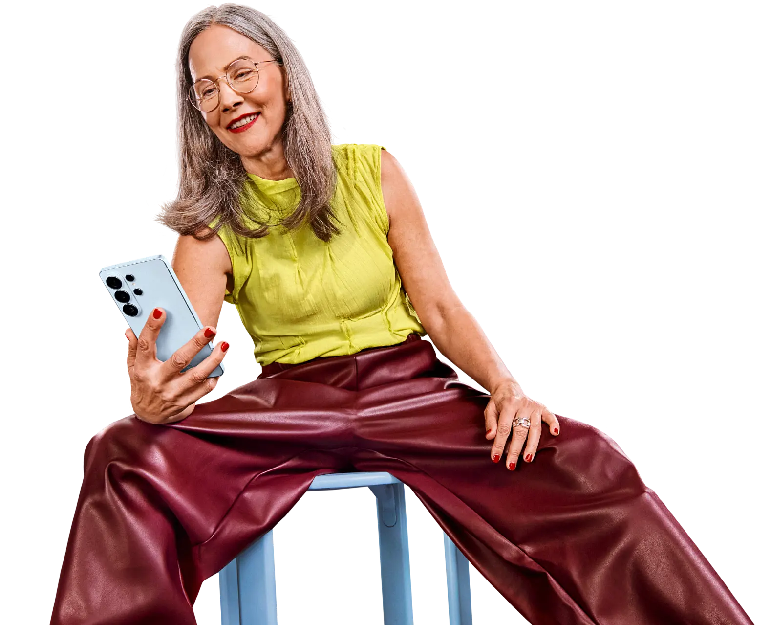 Eine Person sitzt entspannt auf einem Hocker und hält ein Samsung Galaxy Smartphone in der Hand.