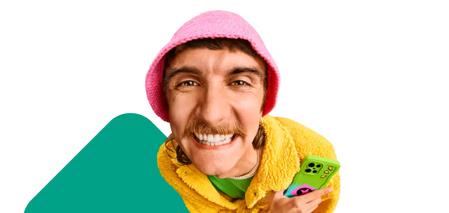 Person lächelt in die Kamera und hält ein Smartphone in der Hand.