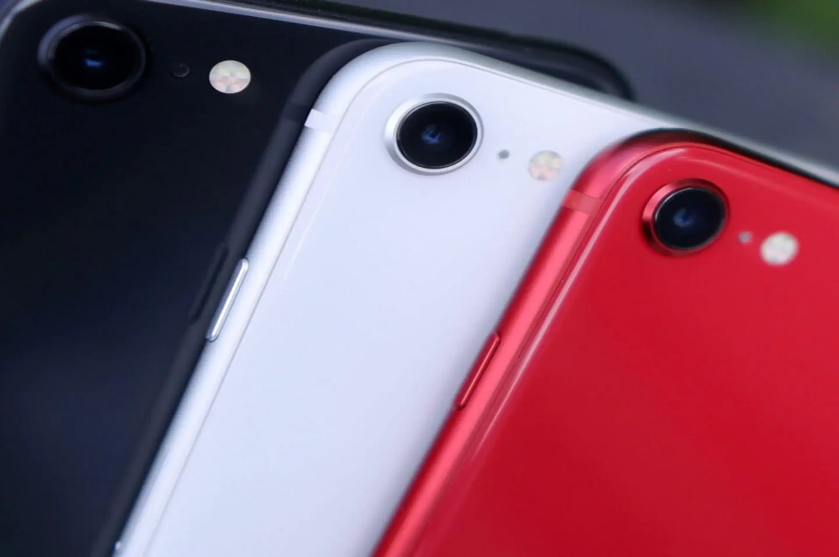 3 iPhones in den Farben schwarz, weiß und rot