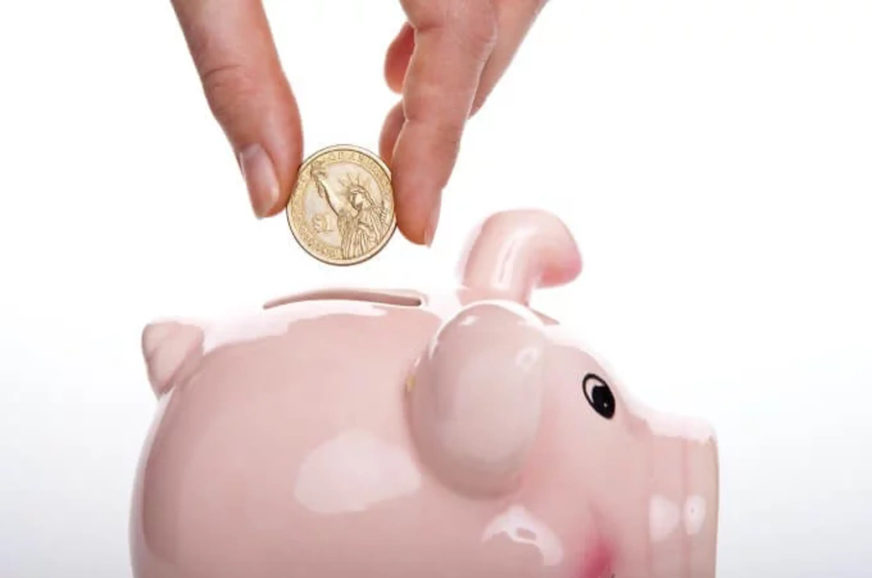 Münze wird in eine Sparschwein geschmissen
