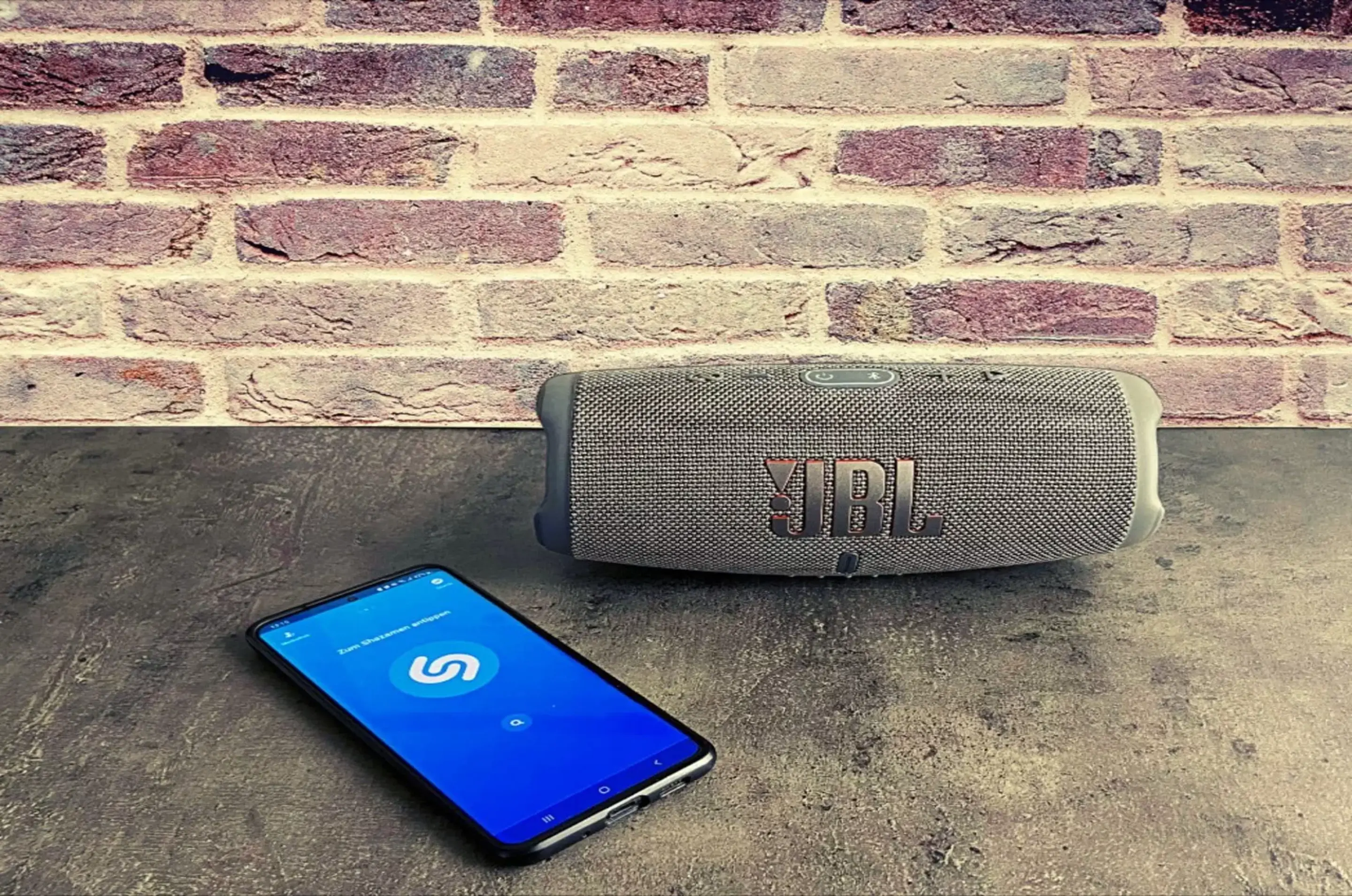 Handy und JBL-Box liegen auf einem Tisch